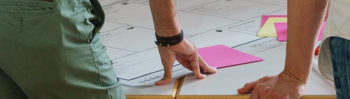 Er ligt een vel papier op tafel waar ideeën op worden geplakt
